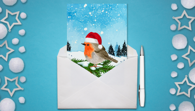 A Christmas card with a picture of a robin on it, half inside an envelope, on a blue background with a festive border