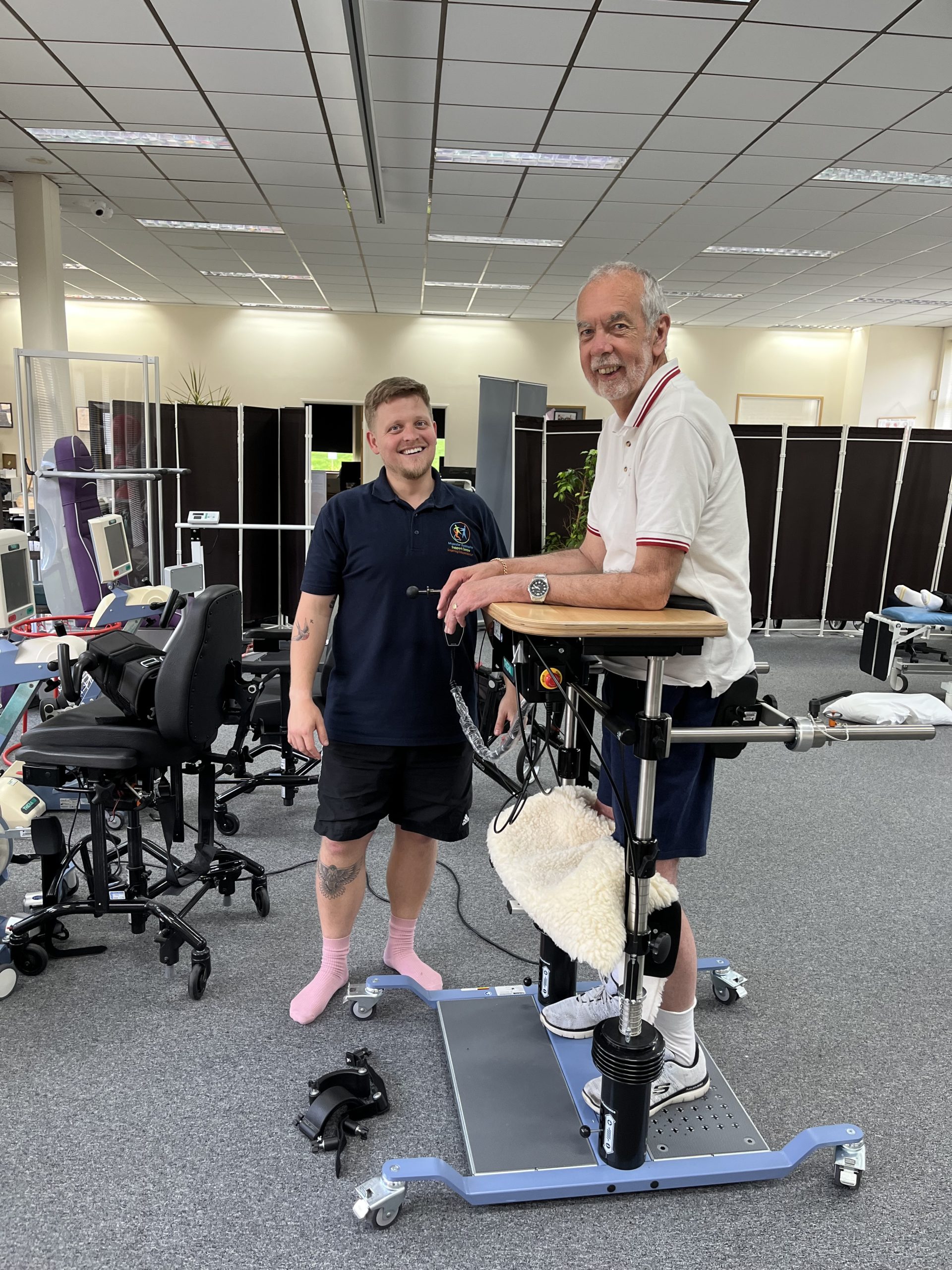 A physiotherapist assisting a service user in the Balo standing frame