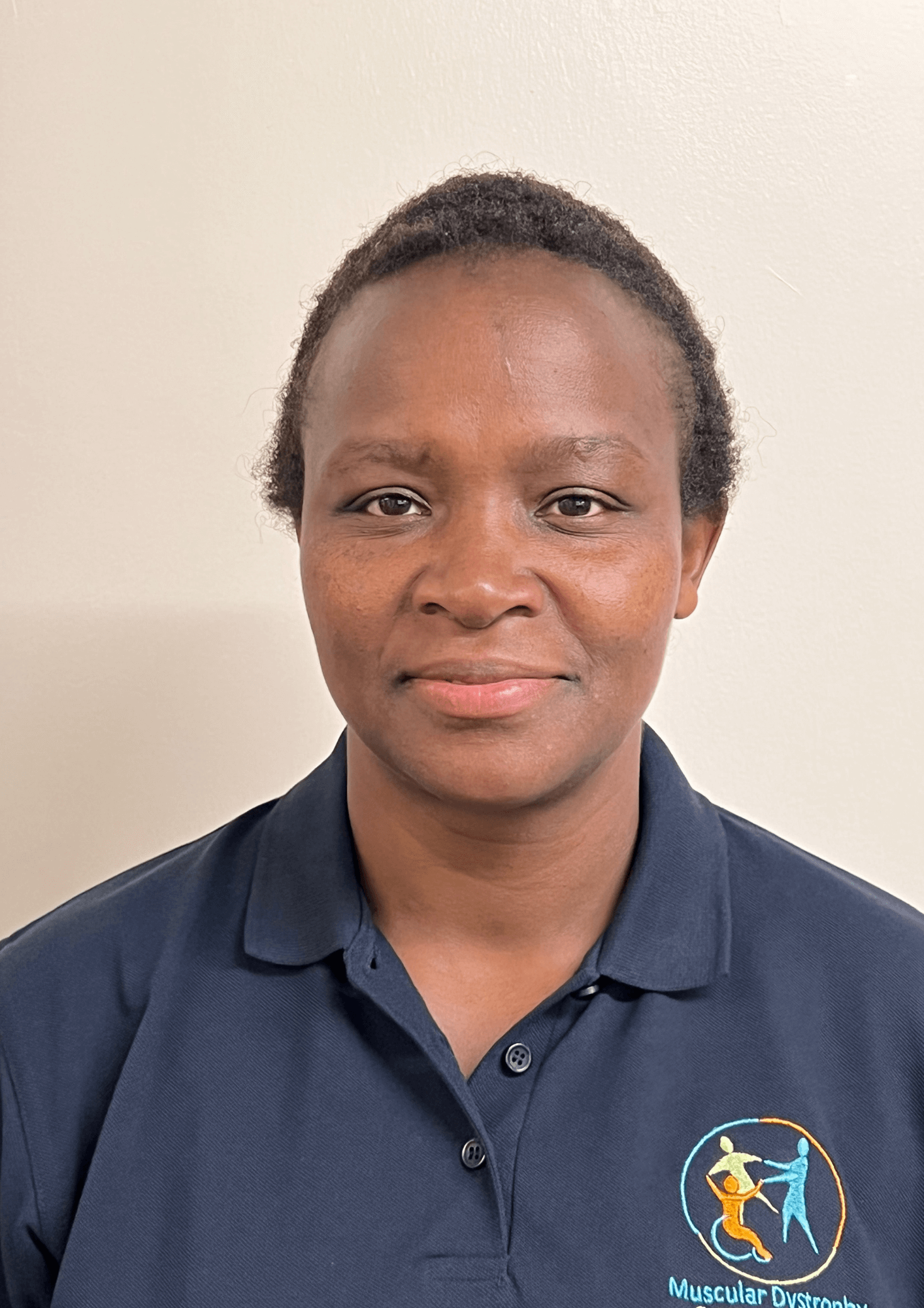 Grace is looking at the camera with a slight smile. She wears a branded MDSC top. Her hair is either cropped short or tied back away from her face.