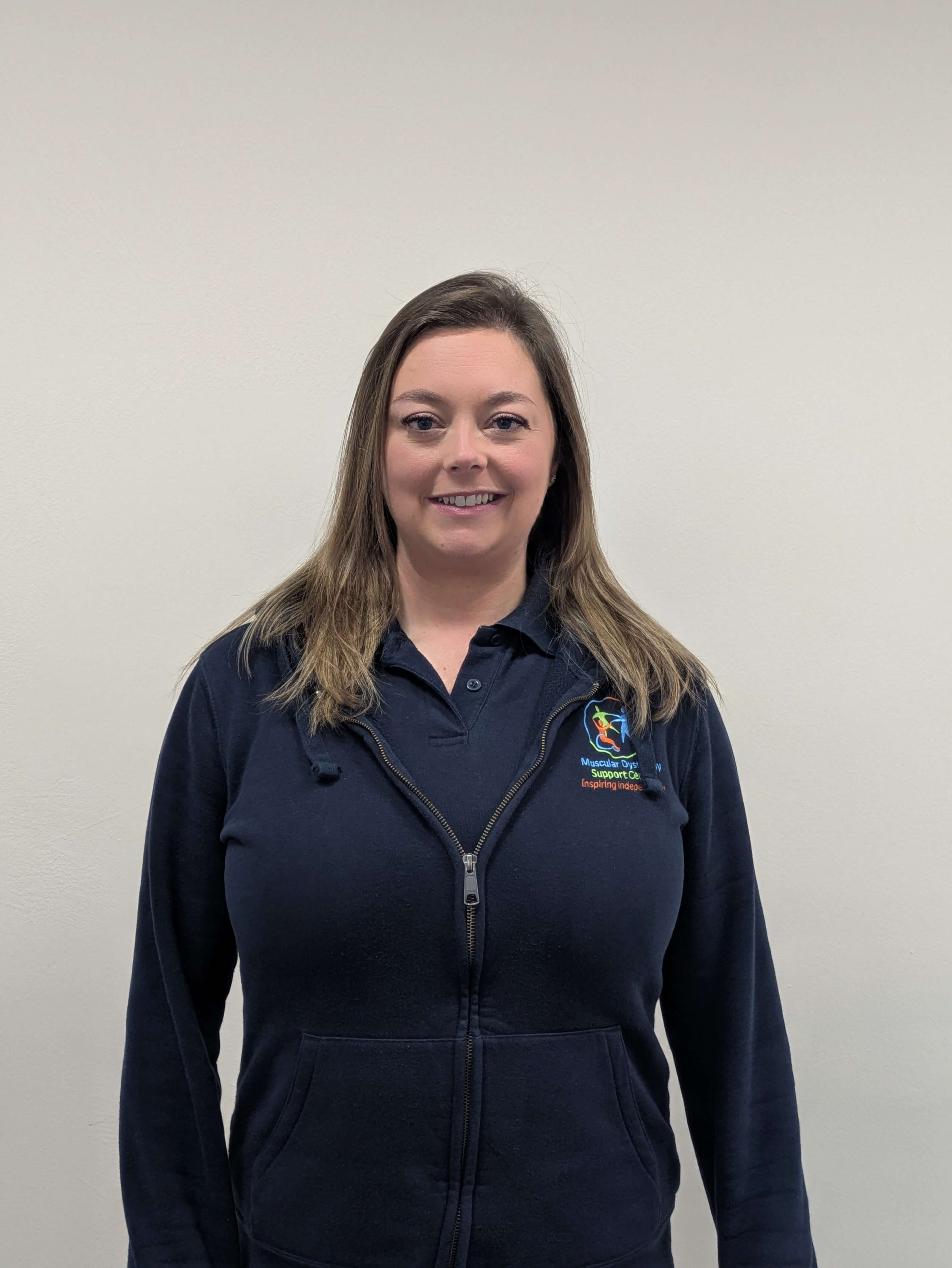 Siobhan is standing in a branded MD Support hoodie in front of a plain cream background.